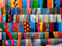 Silk scarves sit on a rack